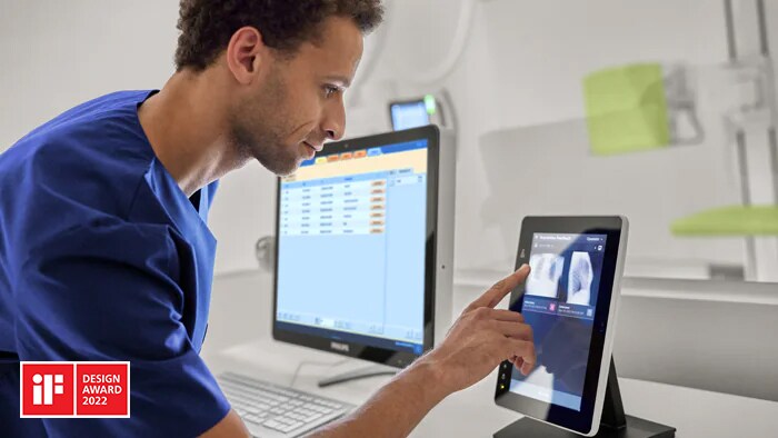 Technologist using smart AI enabled device to review precise positioning results of an X ray exam